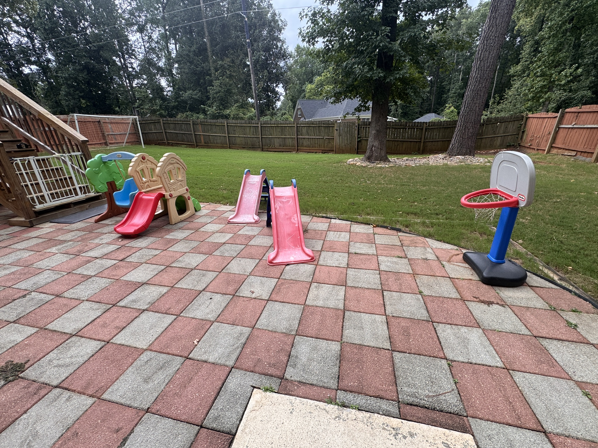 Malik's Daycare outdoor play area with slides and a basketball hoop