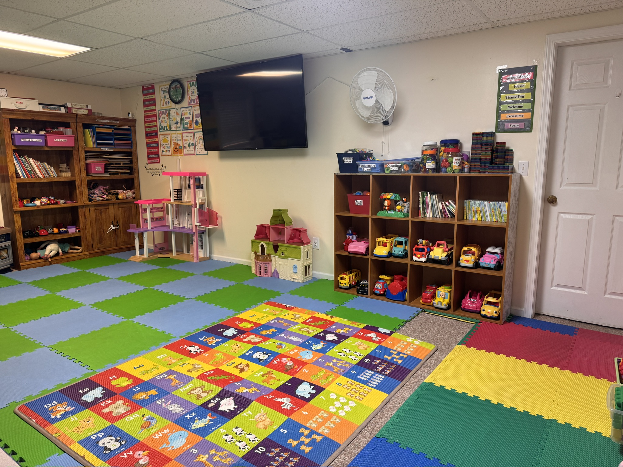 Malik's Daycare playroom with books, toys, and activity mats